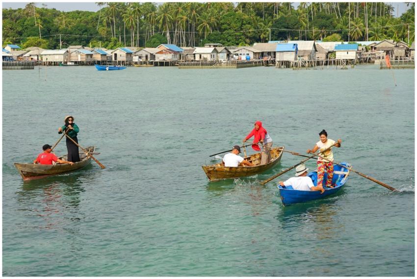 People navigating traditional rowboats in scenic K