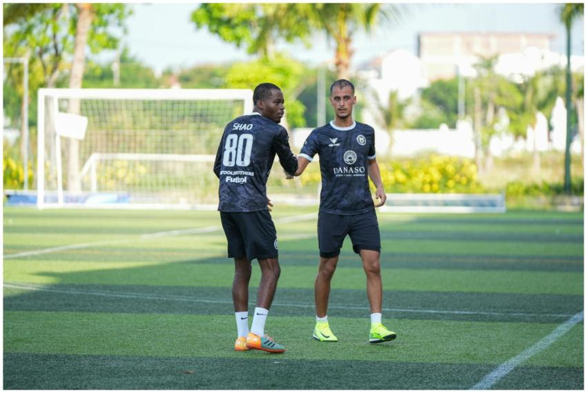 Two soccer players greet each other during practic
