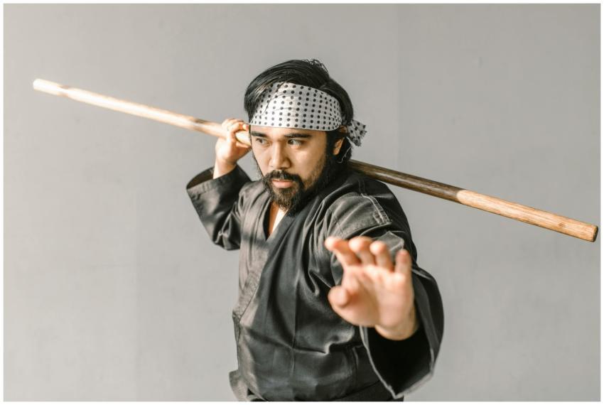 Portrait of a martial artist in black gi practicin