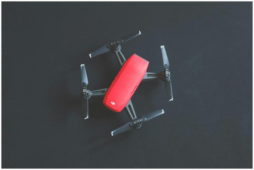 A vibrant red DJI drone captured from above on a b