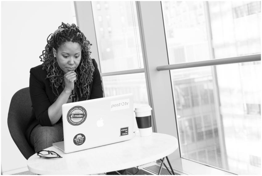 Woman sitting at laptop, focused on remote work. B