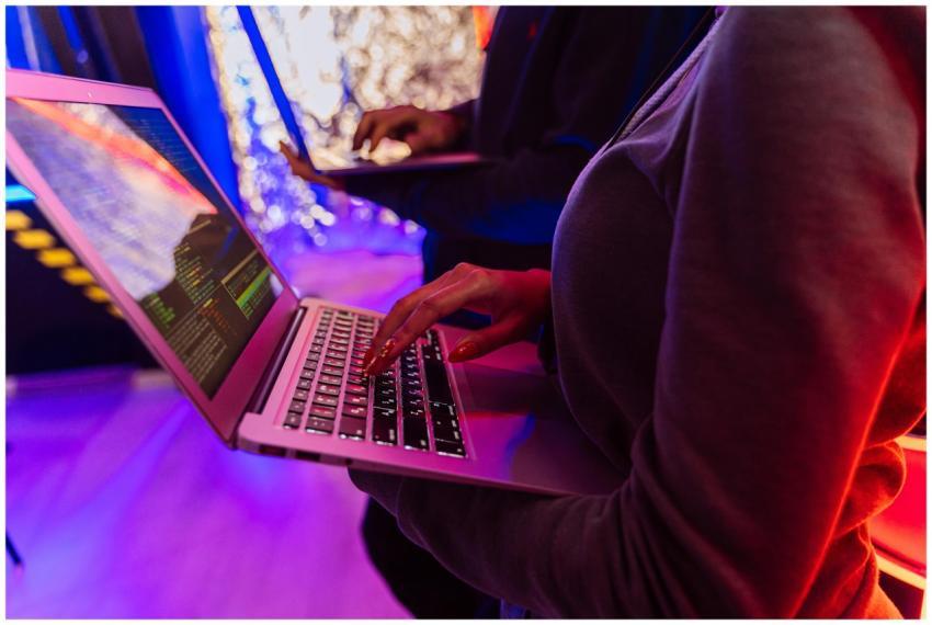 Two professionals analyzing data on laptops with c