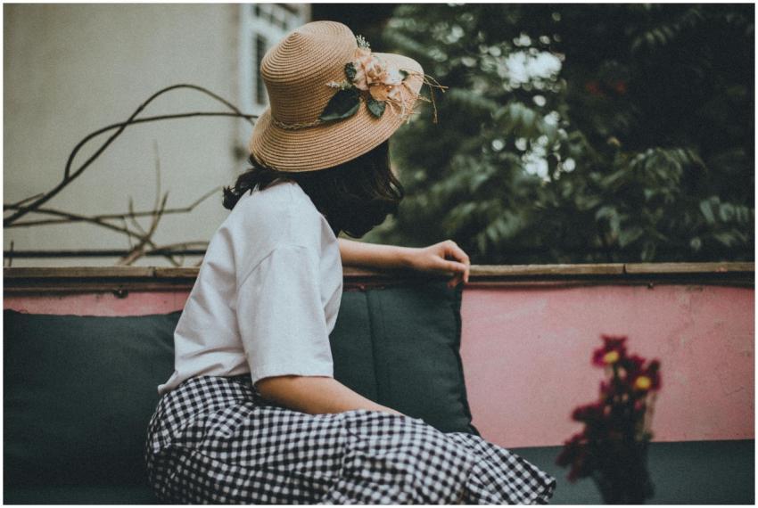 A woman wearing a floral hat enjoys leisure time o