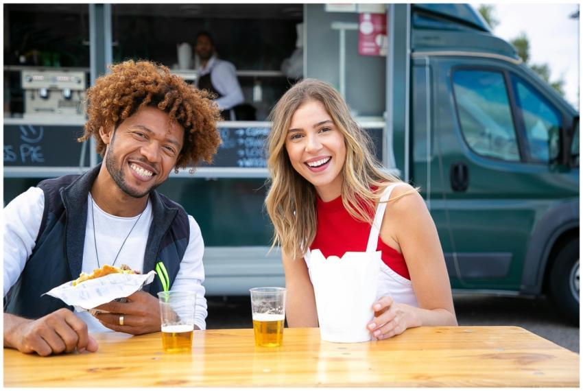 Smiling friends enjoying a meal and drinks at an o