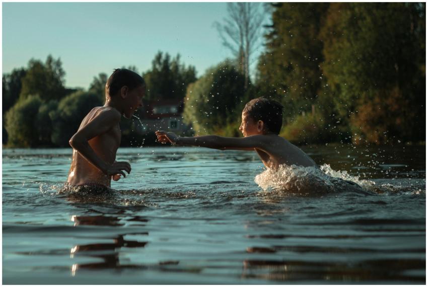 Two boys enjoy a playful splash in the tranquil ou