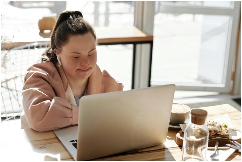 Young woman with Down syndrome using a laptop at h