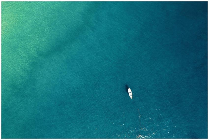 Aerial view of a lone boat on calm turquoise water