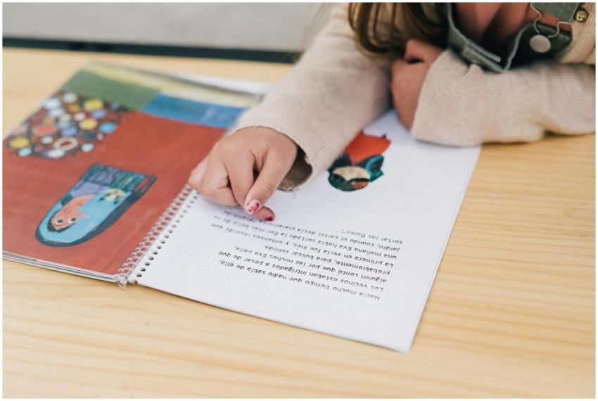 Child's hand pointing at illustrations in a colorf