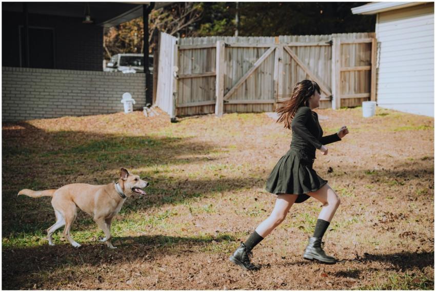 A woman wearing a black dress runs joyfully in a b