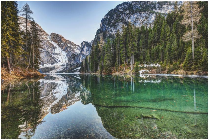 Tranquil lake reflecting snowy mountains and everg