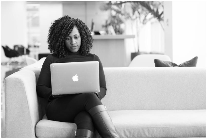 Black and white image of a woman using a laptop on