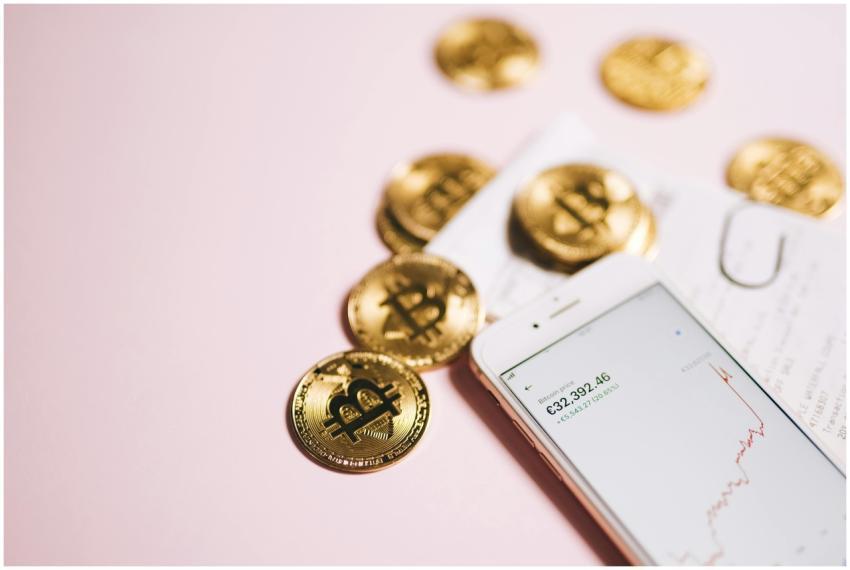 Bitcoin coins with a smartphone displaying financi