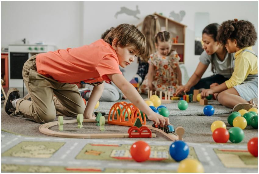 Children engaged in play with toys and an educator