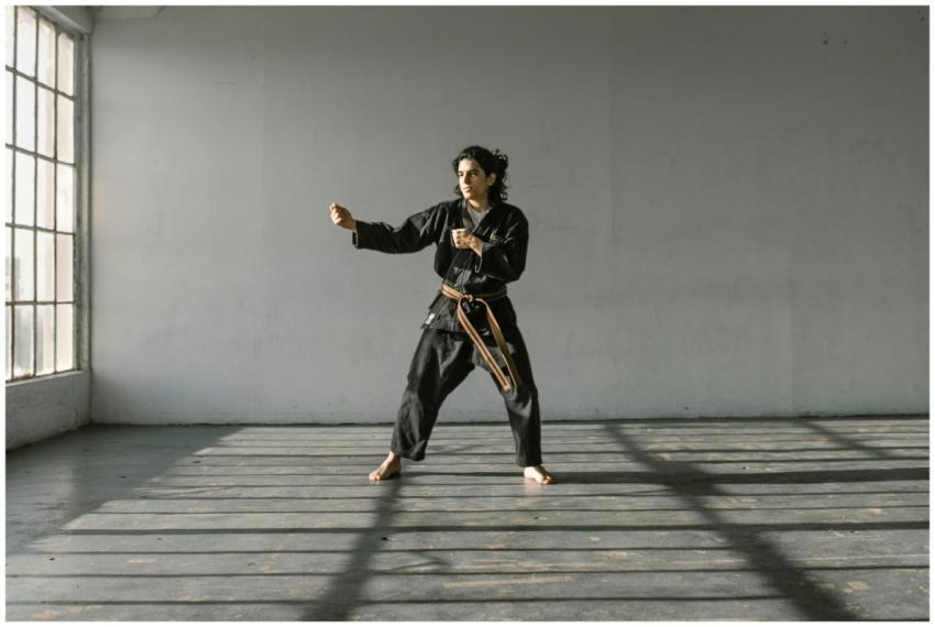 Martial artist performs a kata in a well-lit dojo,