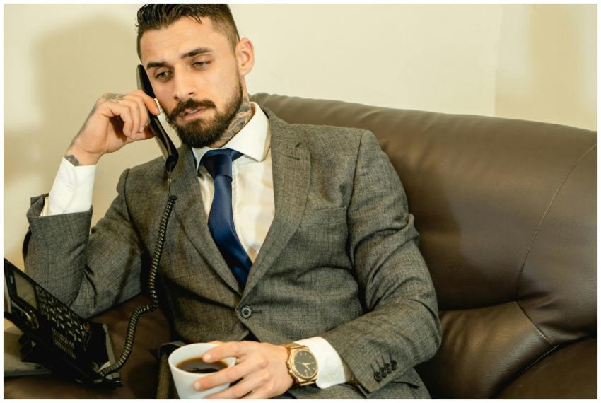 Bearded businessman in a gray suit talking on the