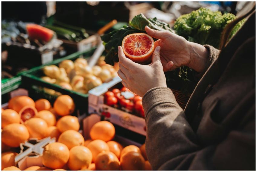 A close-up of a person holding a sliced orange at
