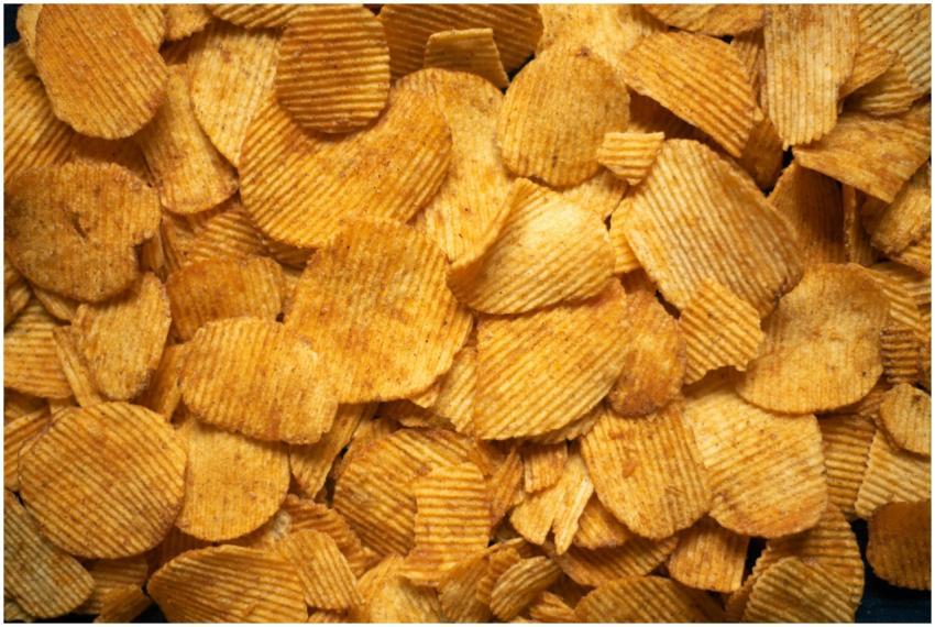 A delicious pile of golden crispy potato chips vie