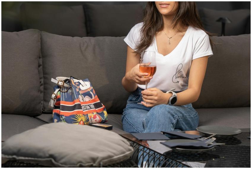 A woman relaxing indoors with a glass of wine, enj