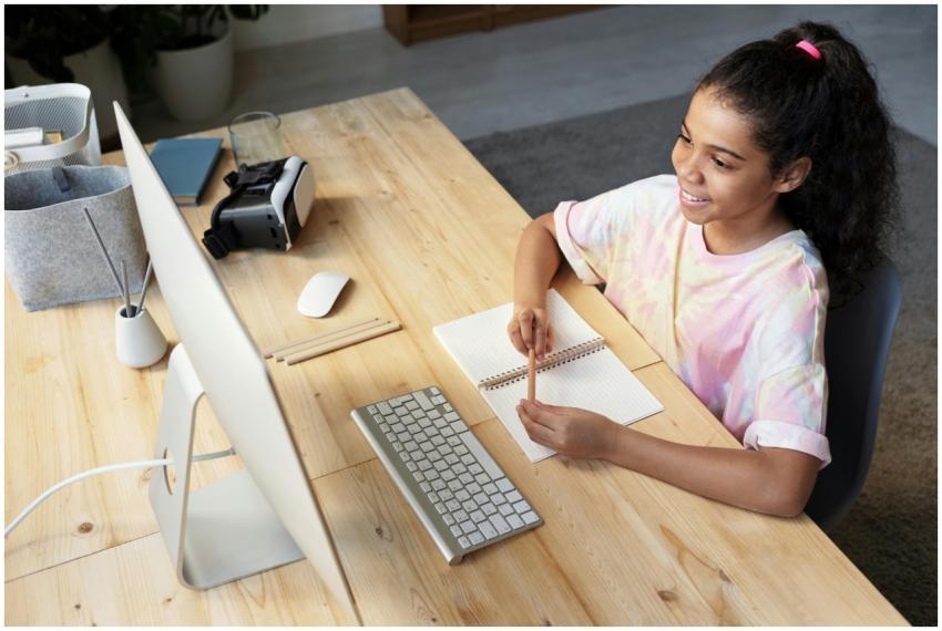 A young girl smiling while studying online at home