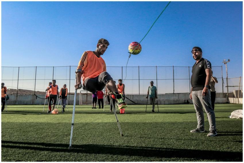 A group of amputee soccer players train with a bal