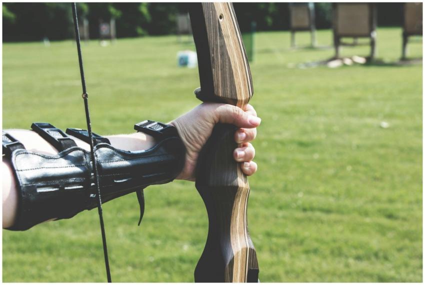 Close-up of an archer's hand holding a bow, ready