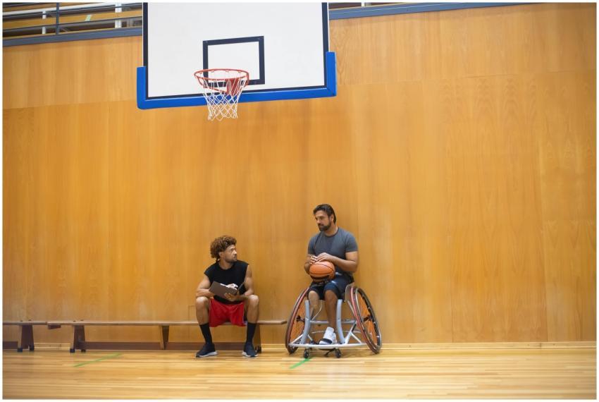 Two men in a basketball gym, one in a wheelchair,