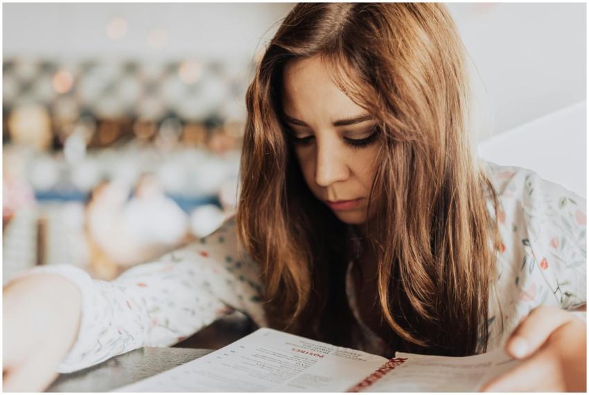 Young woman intensely focused on reading a menu in