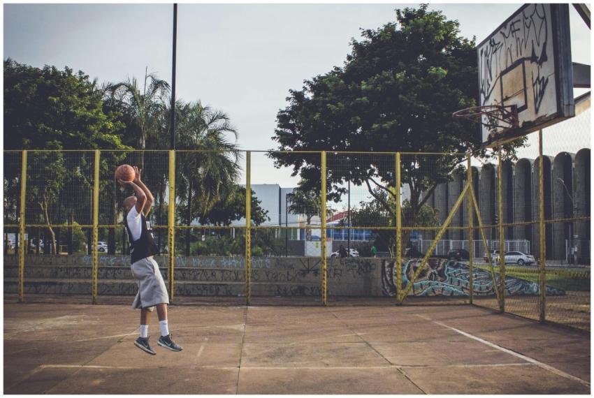 A man in athletic wear leaps for a basketball shot