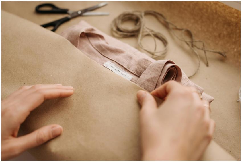 Close-up of hands wrapping a linen shirt with twin