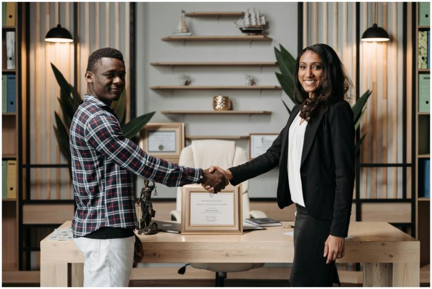 Two professionals shaking hands in an office setti
