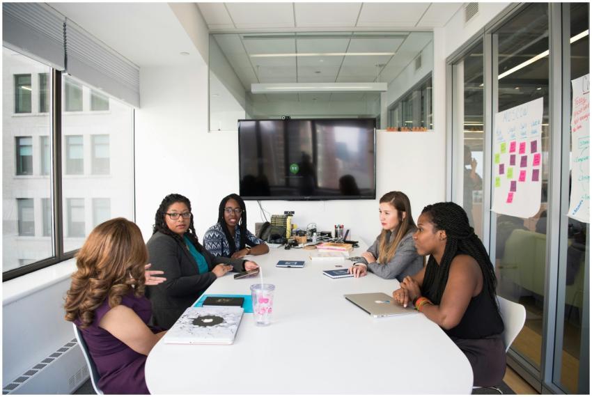 Five diverse women collaborating in a modern offic