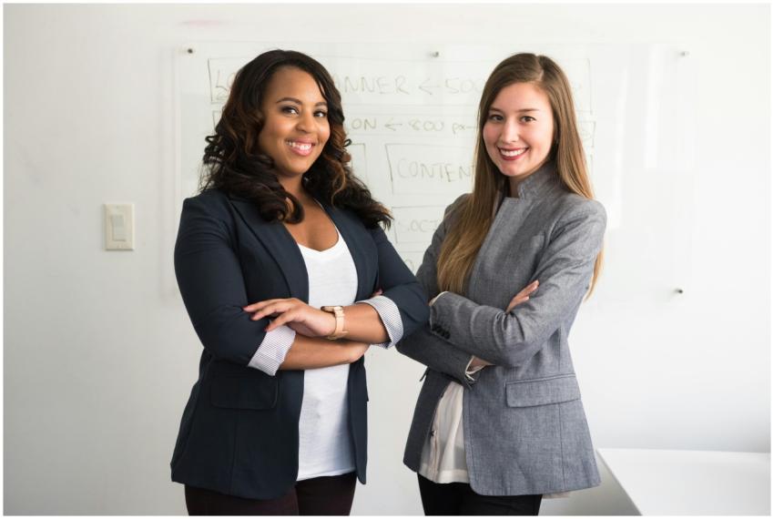 Two diverse businesswomen smiling confidently in a