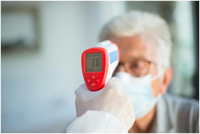 A healthcare professional uses a digital thermomet