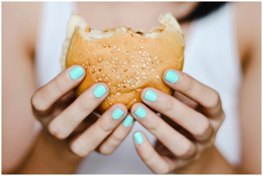 A close-up shot of hands with blue nails holding a