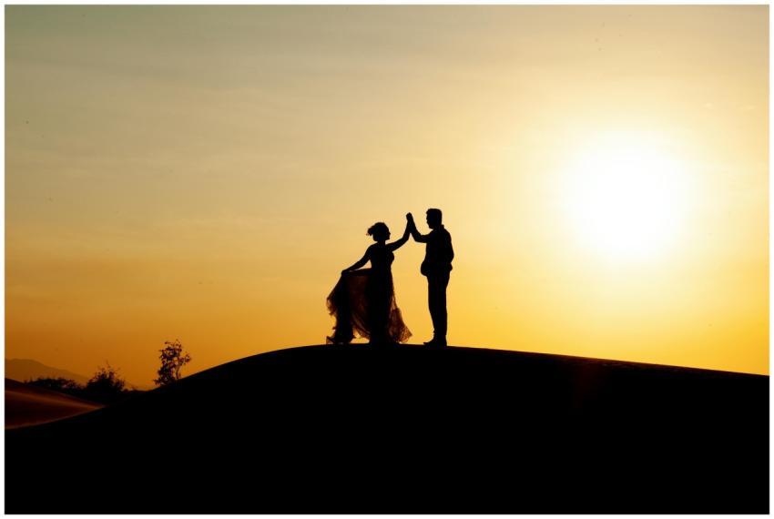 Silhouetted couple dancing on the beach during a g
