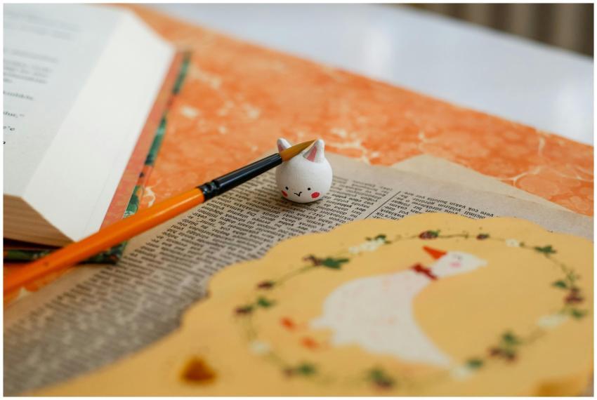 Creative flat lay with open book, paintbrush, and