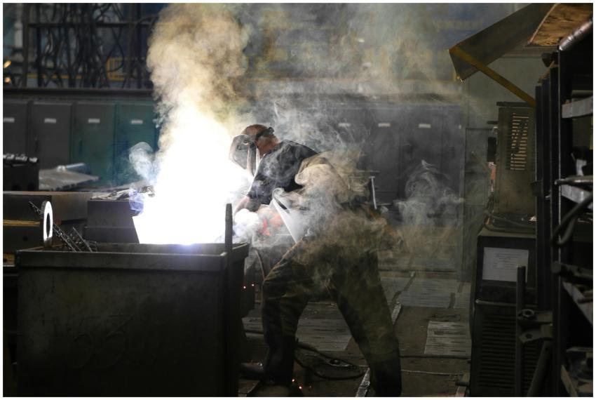 A skilled welder working with intense sparks and s