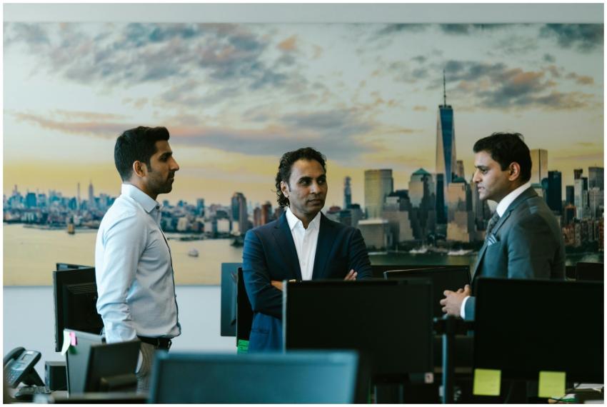 Three businessmen in a meeting with a city skyline