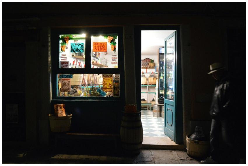 Charming night view of a Venetian shop with open d