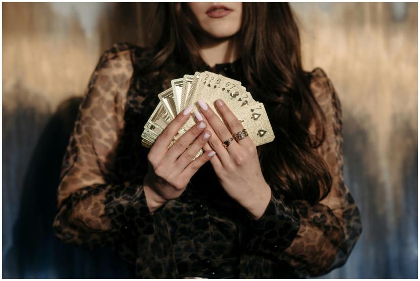 Close-up of a woman holding gold cards, creating a