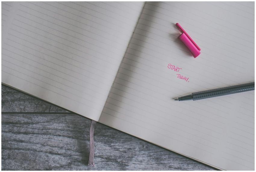 Open lined notebook with a pink highlight and pen
