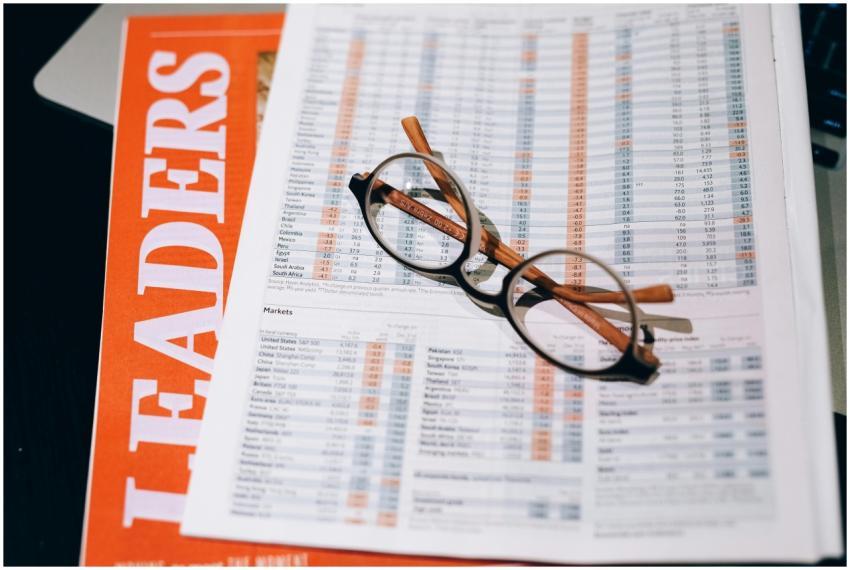 A pair of eyeglasses resting on a financial docume