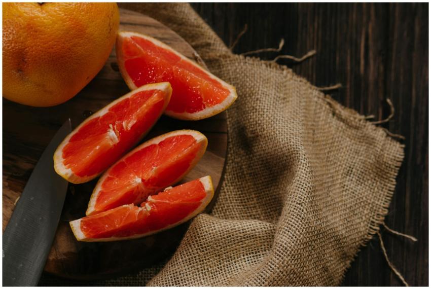 Close-up of fresh grapefruit slices on a rustic wo