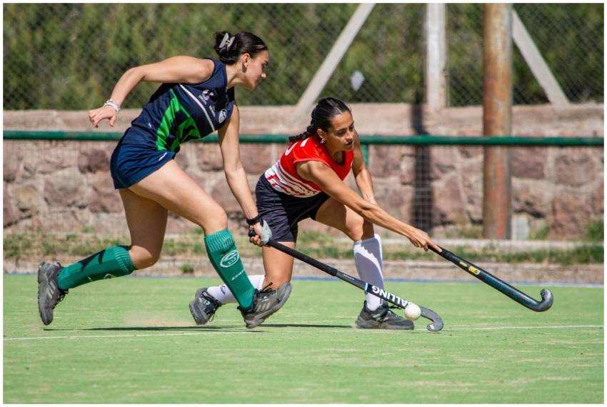 Two female athletes engaged in an intense field ho