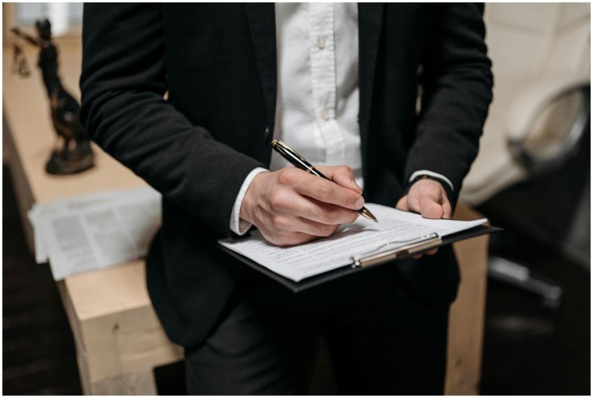 Business professional signing a contract on a clip