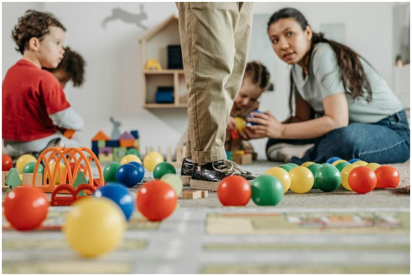 Children and a teacher playing with toys in a kind