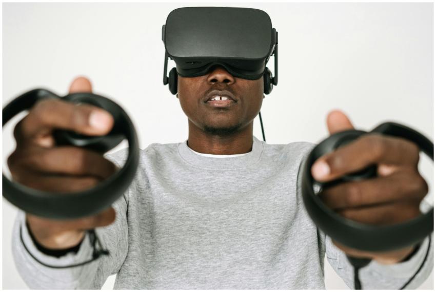 Focused man using VR headset and controllers immer
