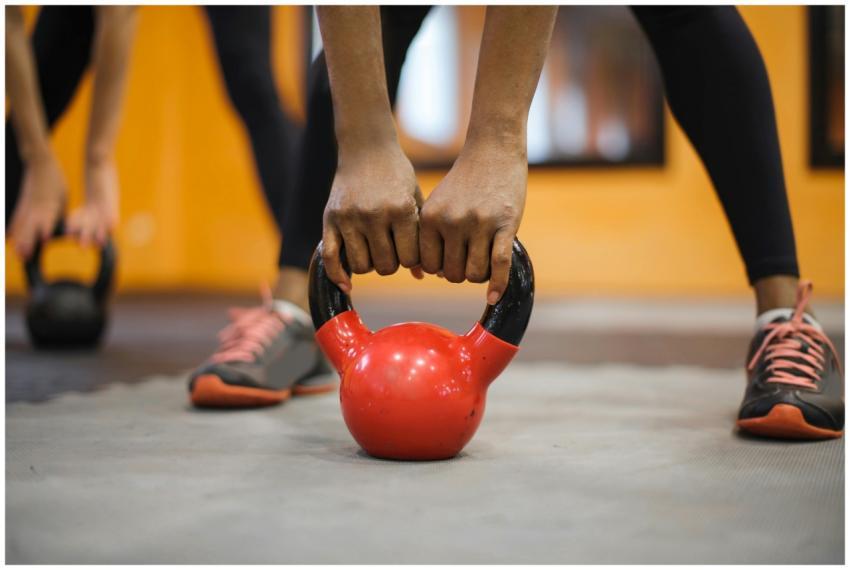 Close-up of hands gripping a red kettlebell in a v