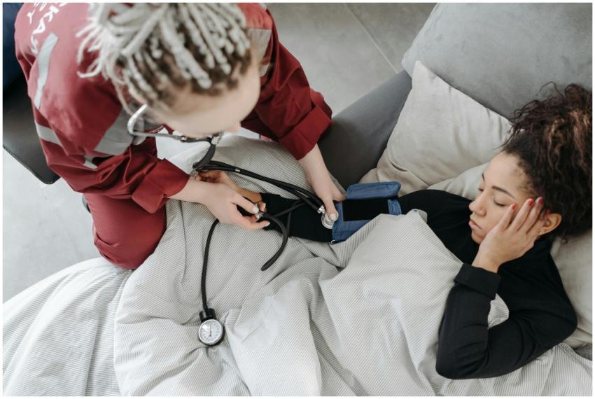 Paramedic measuring patient's blood pressure indoo