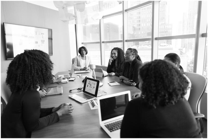 Black women collaborating in a modern office meeti